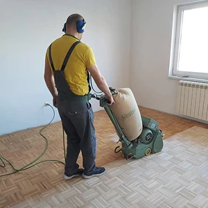 Radnik koristi mašinu za brušenje parketa - glatka i ujednačena površina