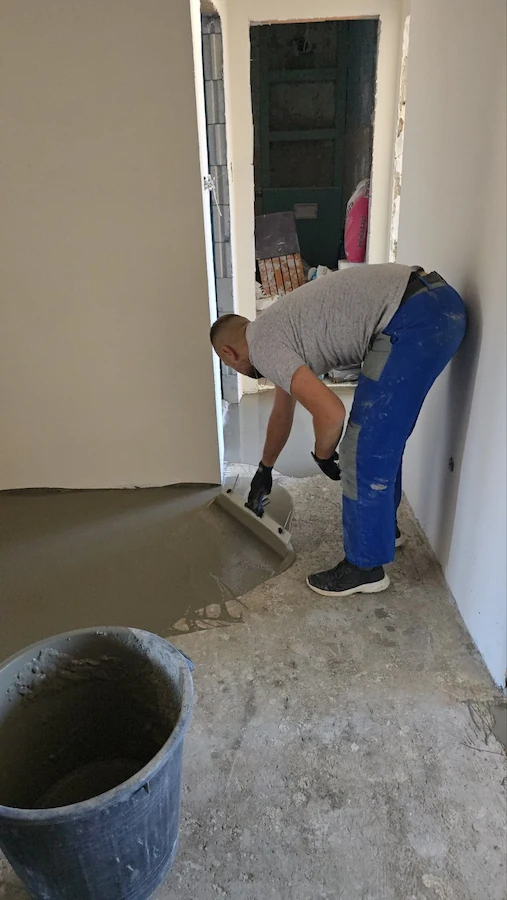 Majstor precizno niveliše pod i finalizira pripremu za postavljanje parketa