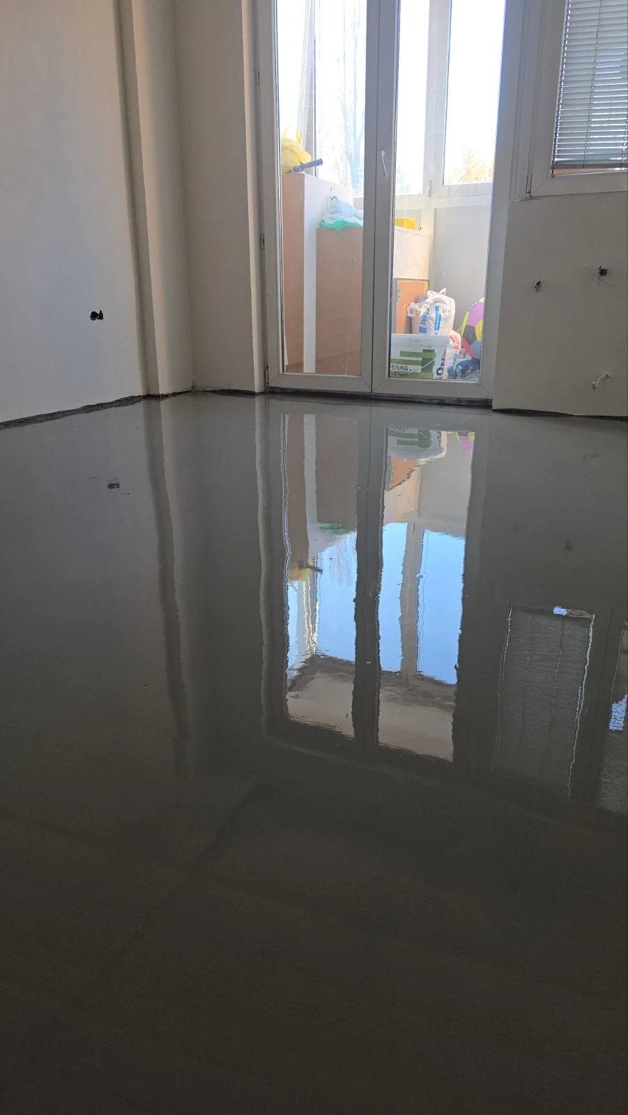 Radnik firme Parket Dino nanosi novi sloj kvalitetnog materijala za nivelisanje poda